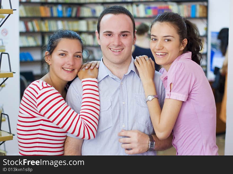 Three happy students in library. Three happy students in library