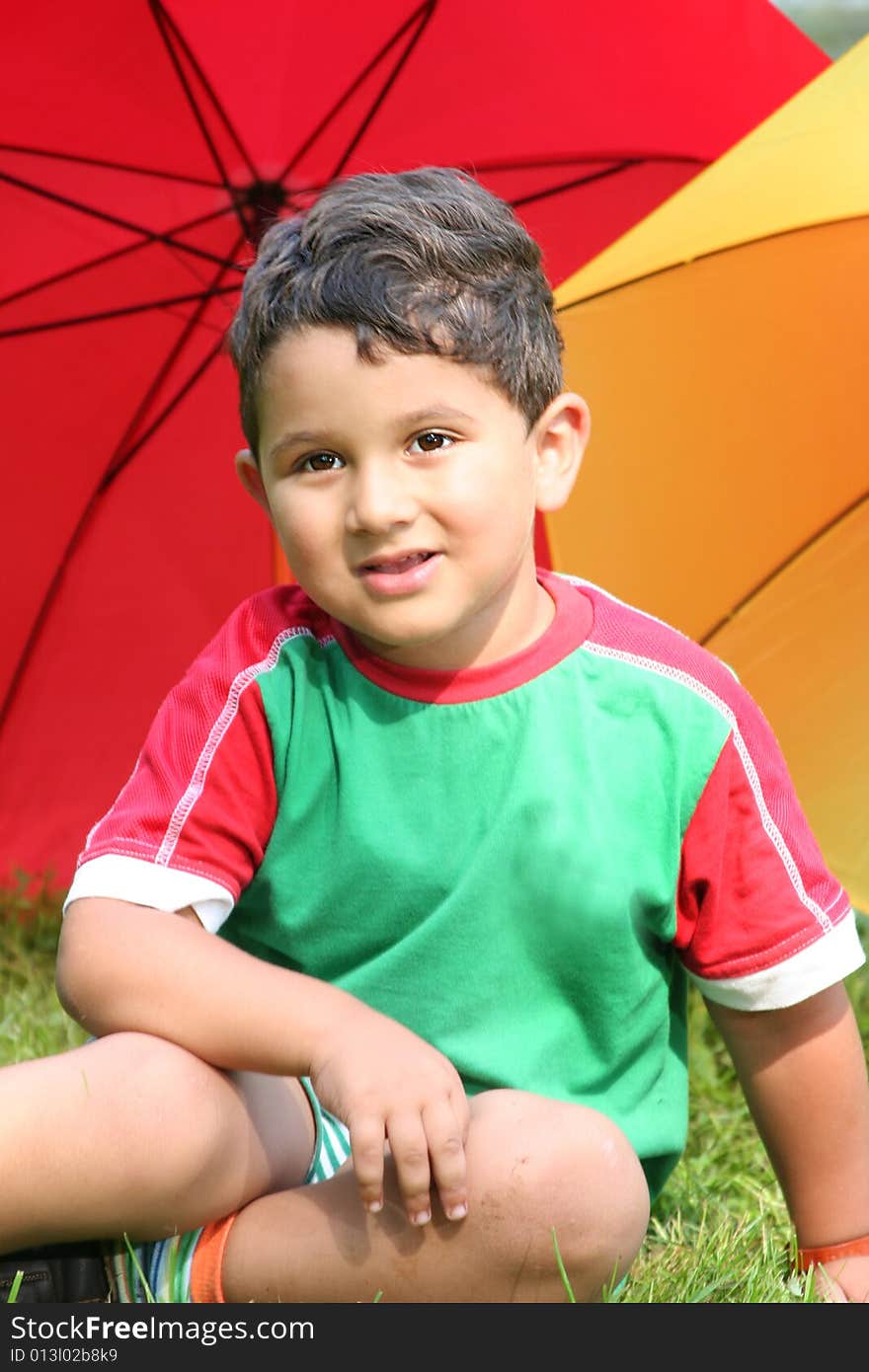 Funny little kid with colorful umbrellas