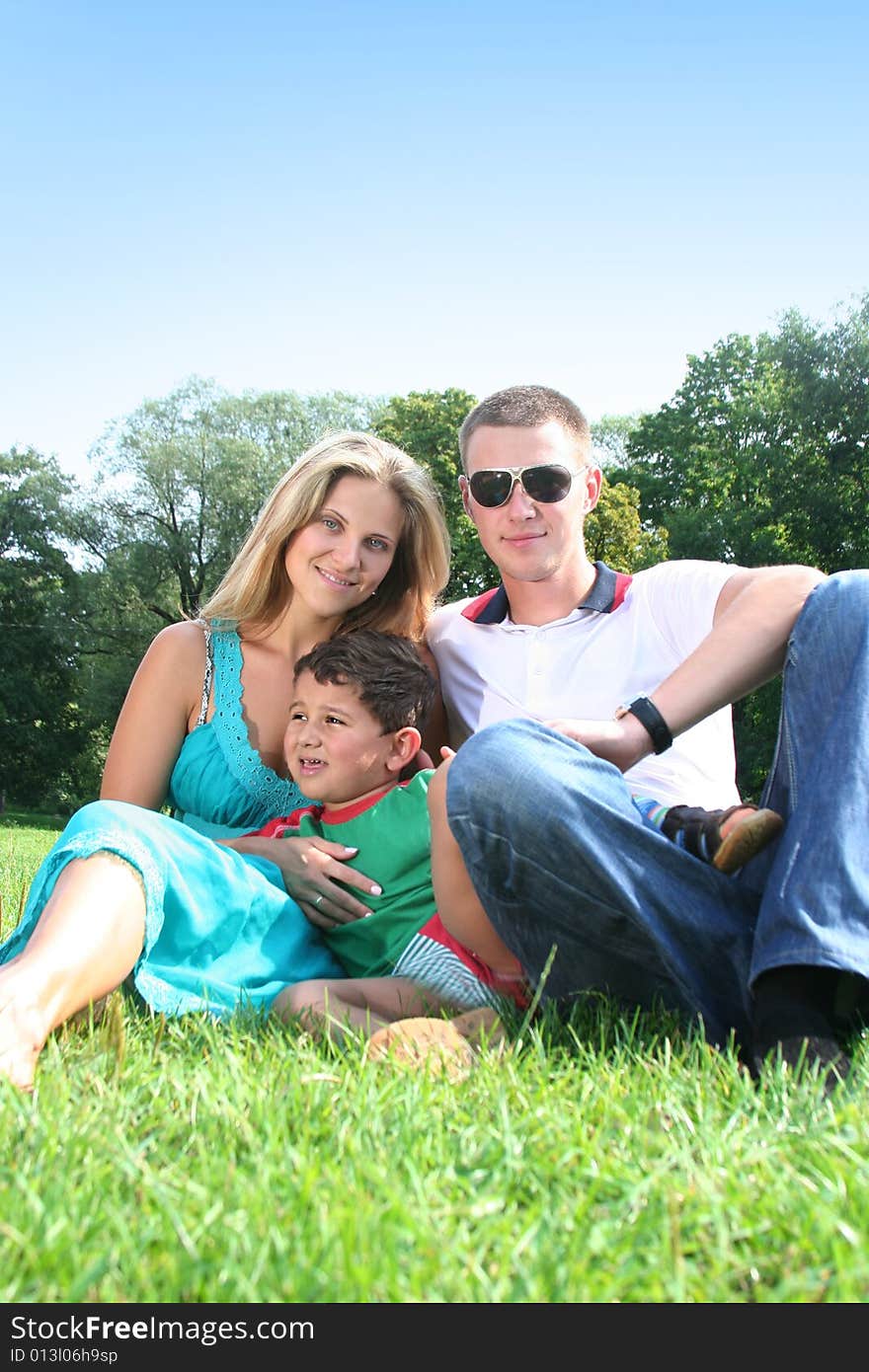 Happy family relaxing in park. Happy family relaxing in park