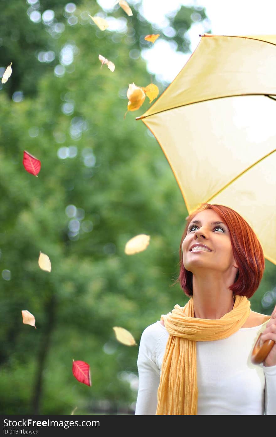 Beautiful young girl under yellow umbrella in the autumn park. Beautiful young girl under yellow umbrella in the autumn park