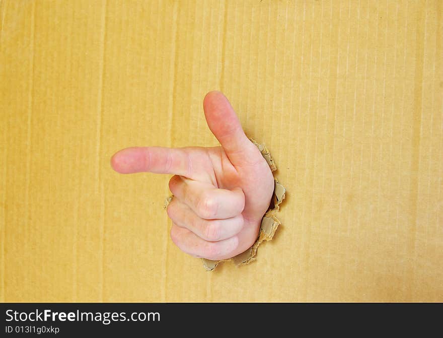 Hand pointing with index finger against a cardboard background