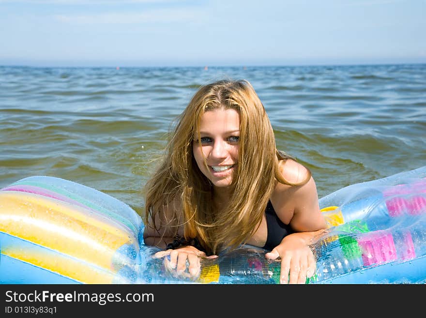 Beautiful girl swimming on mattress