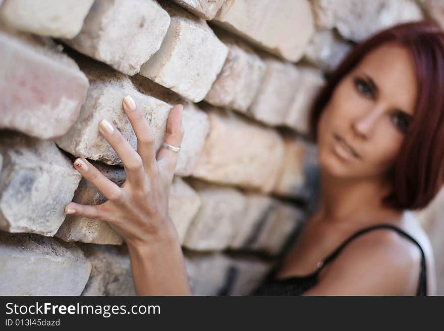 young girl near old wall (hand in focus)