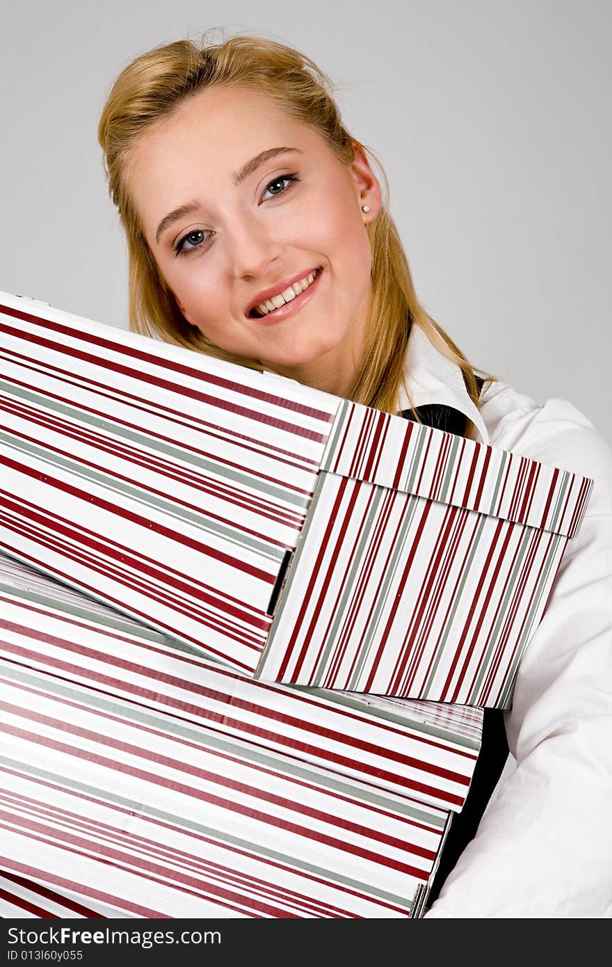 Smiling young woman with stack of boxes