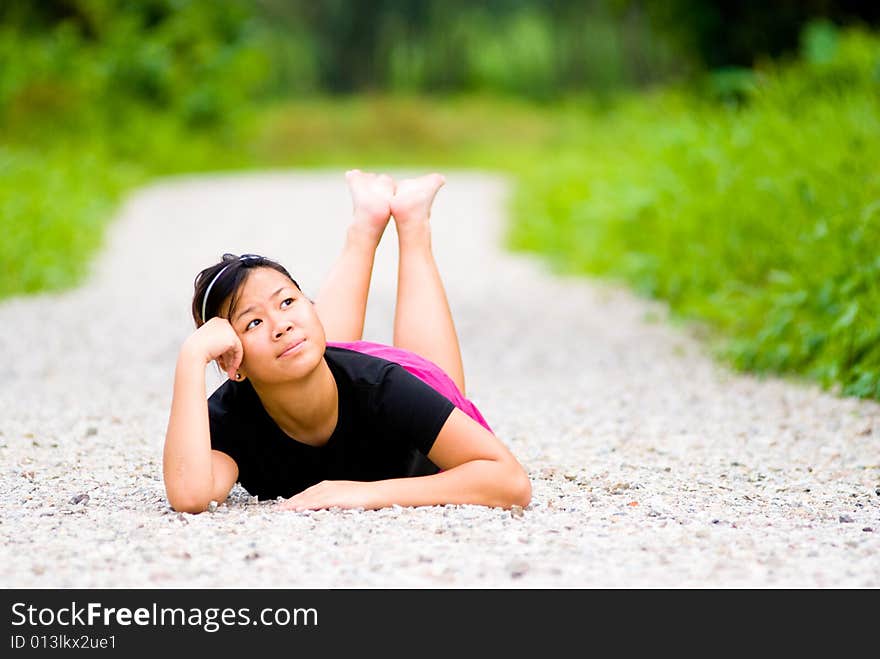 Barefooted girl reminiscing while sprawl on a foot trail. Barefooted girl reminiscing while sprawl on a foot trail