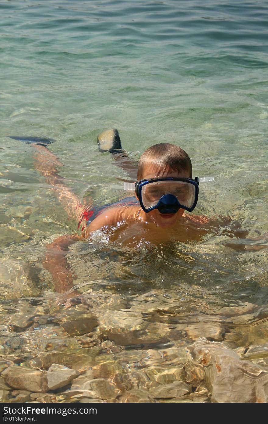 Boy on a beach ready to swim. Boy on a beach ready to swim