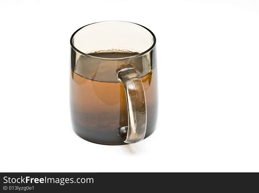 A transparent black cup with tea and tealeafs