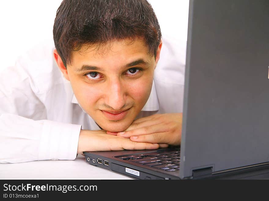 Young man looks away from laptop with smile. isolated on white background. Young man looks away from laptop with smile. isolated on white background