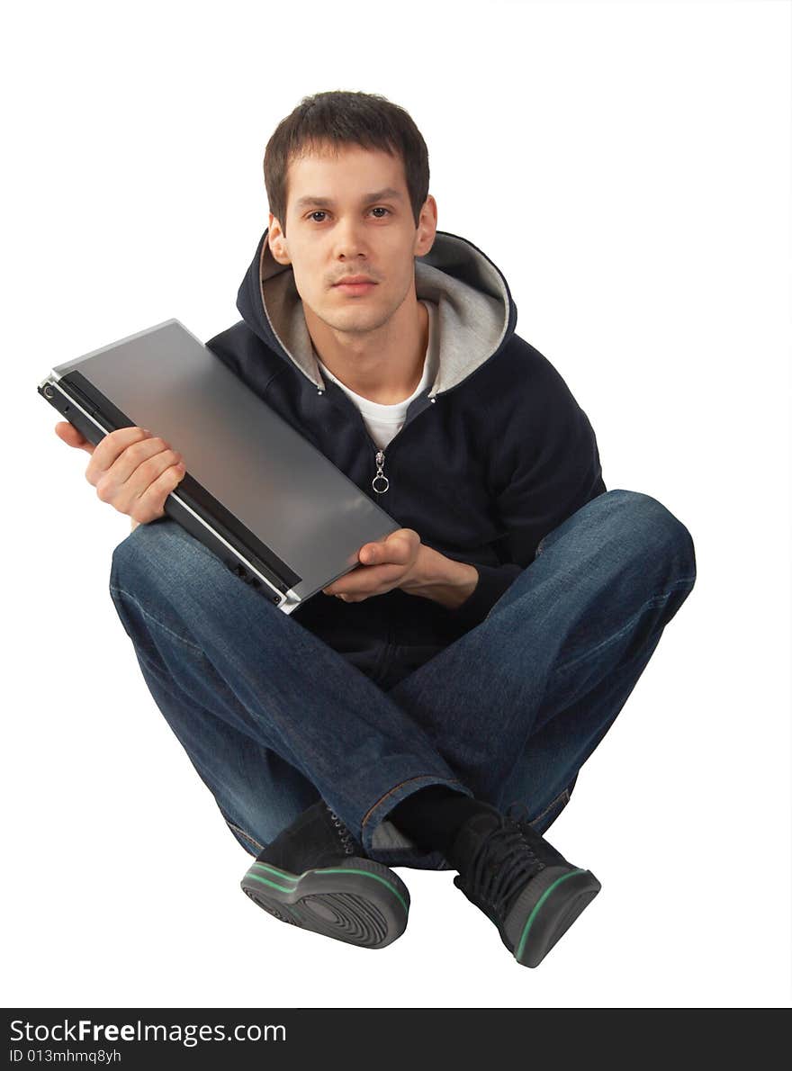 Young man with laptop sits on floor