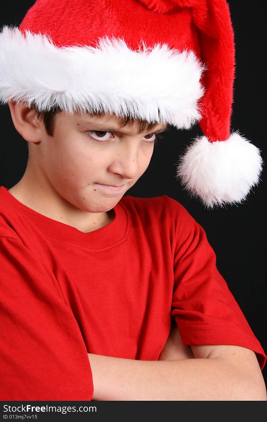 Young boy wearing a red shirt and christmas hat. Young boy wearing a red shirt and christmas hat