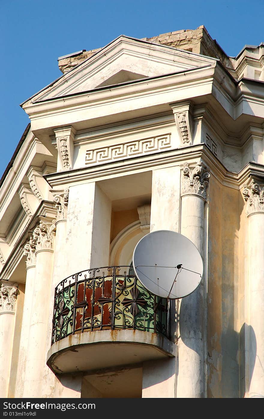 Dish aerial mounted on old rusty balcony