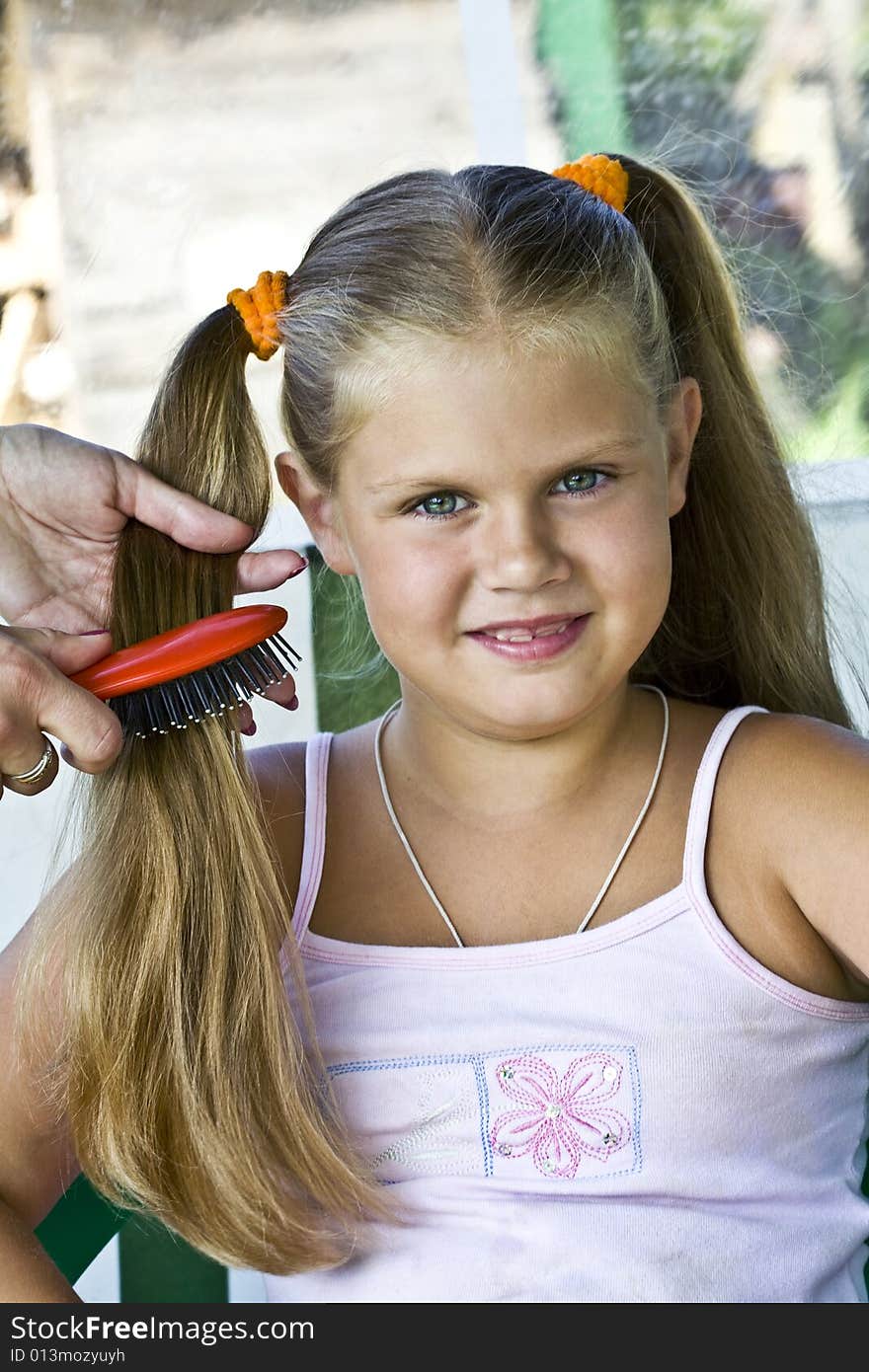 Little blond long hair girl has haircare by stylist. Little blond long hair girl has haircare by stylist.