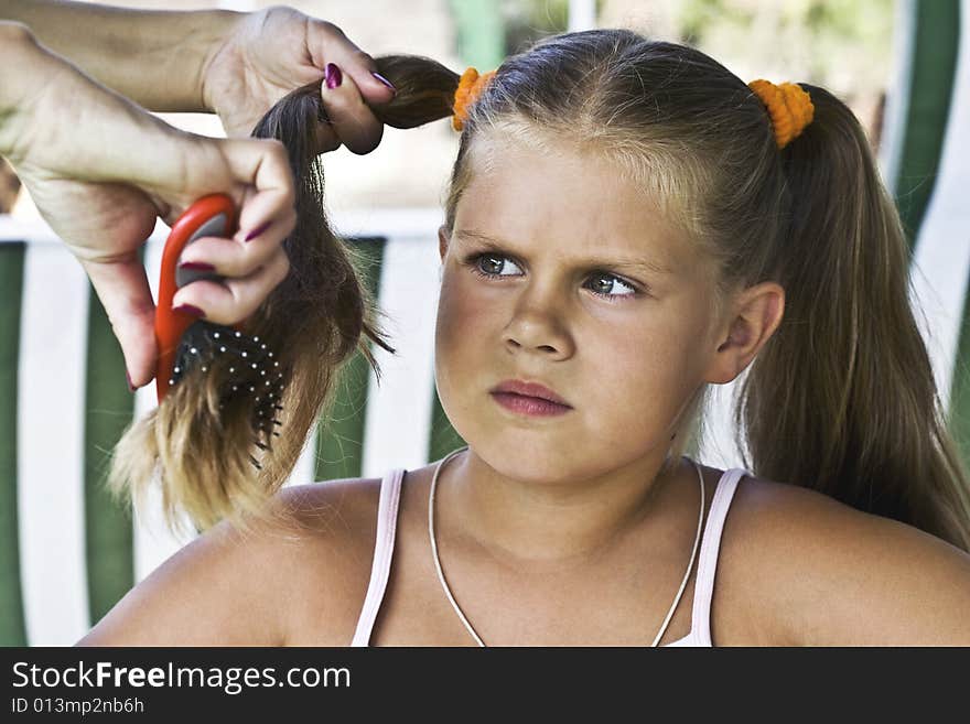 Little blond long hair girl has haircare by stylist. Little blond long hair girl has haircare by stylist.