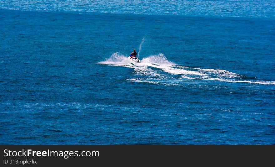 The racer on the scooter in the high sea