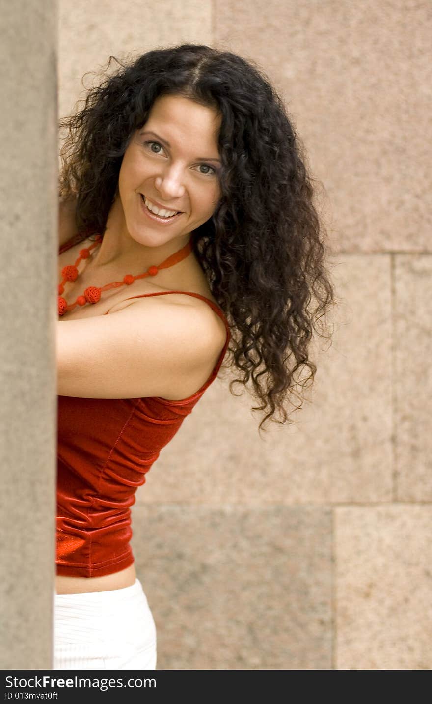 Outdoor portrait of pretty brunette near column