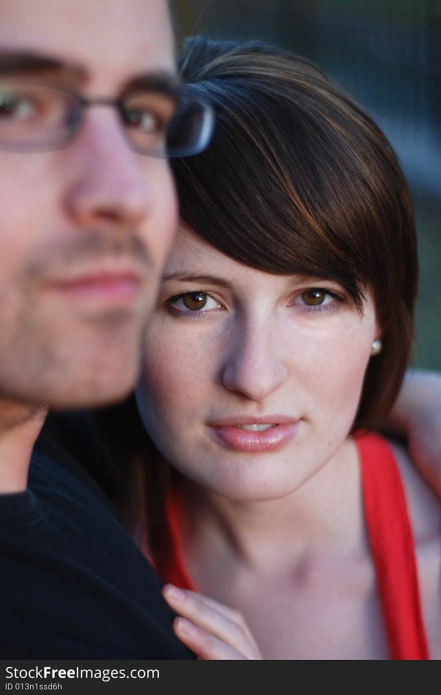 A young couple close together looking out