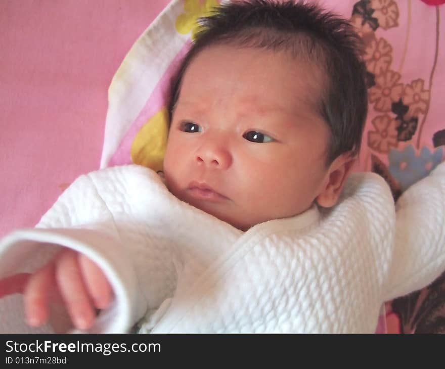 Lovely baby in white on a bed