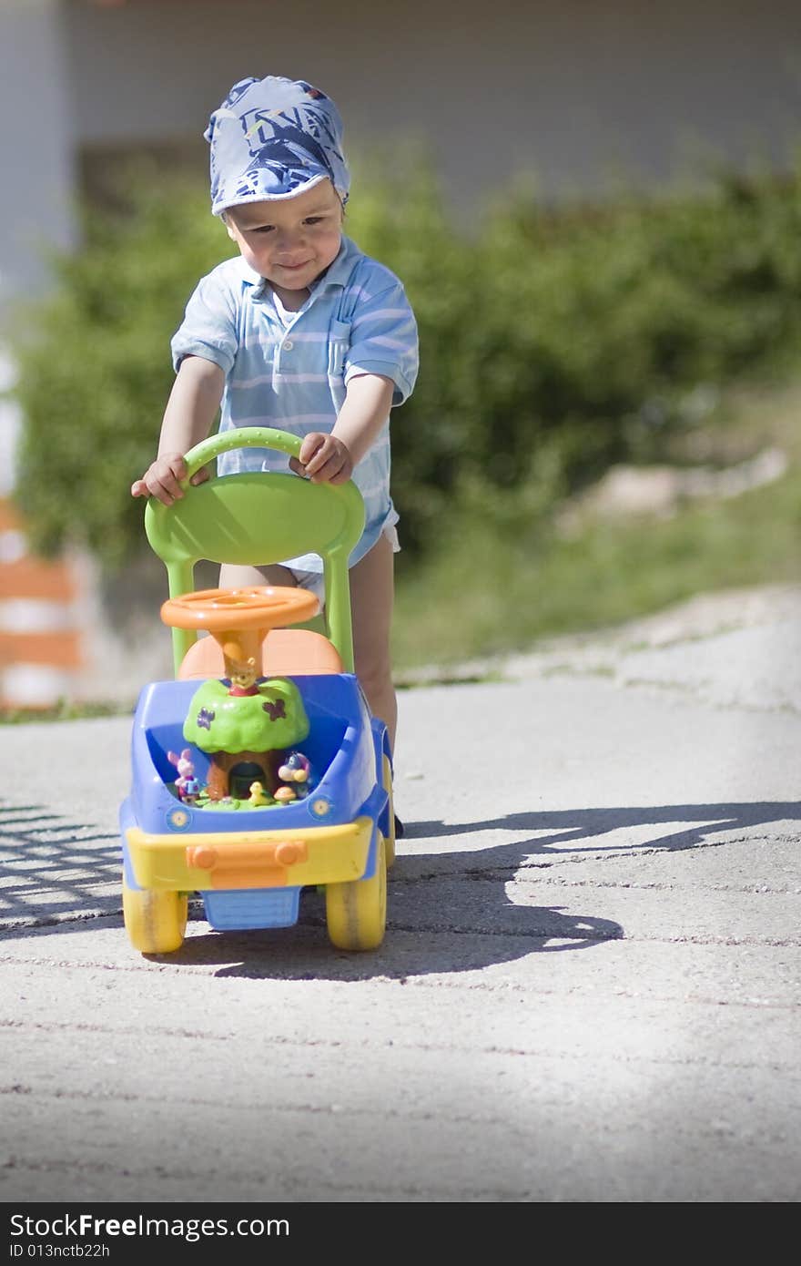 Young human with small car in summer