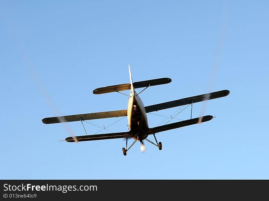 Airplane spraying, isolated over blue sky. Airplane spraying, isolated over blue sky