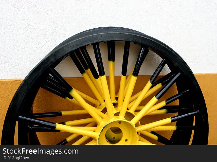 Yellow detail in the wall and yellow and black Wheel cart - typical in Portugal. Yellow detail in the wall and yellow and black Wheel cart - typical in Portugal