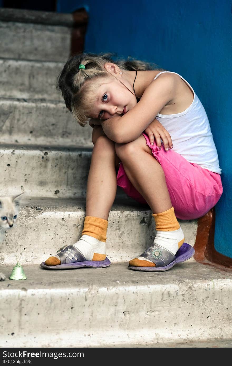 Little girl is sitting on concrete stairs. Little girl is sitting on concrete stairs