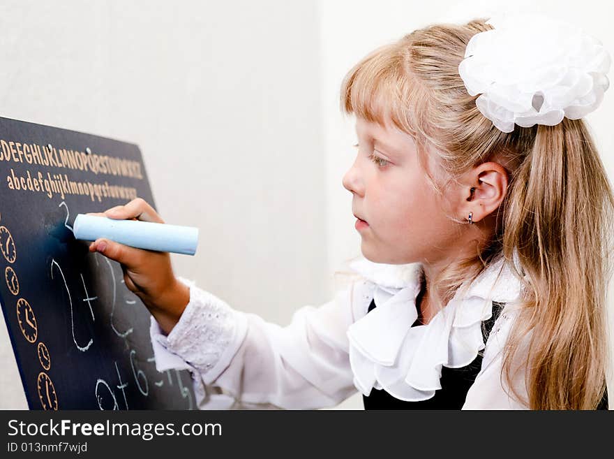 An image of Little girl writing on blackboard. An image of Little girl writing on blackboard.