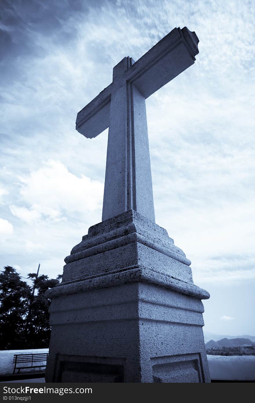 Christian stone cross under blue sky