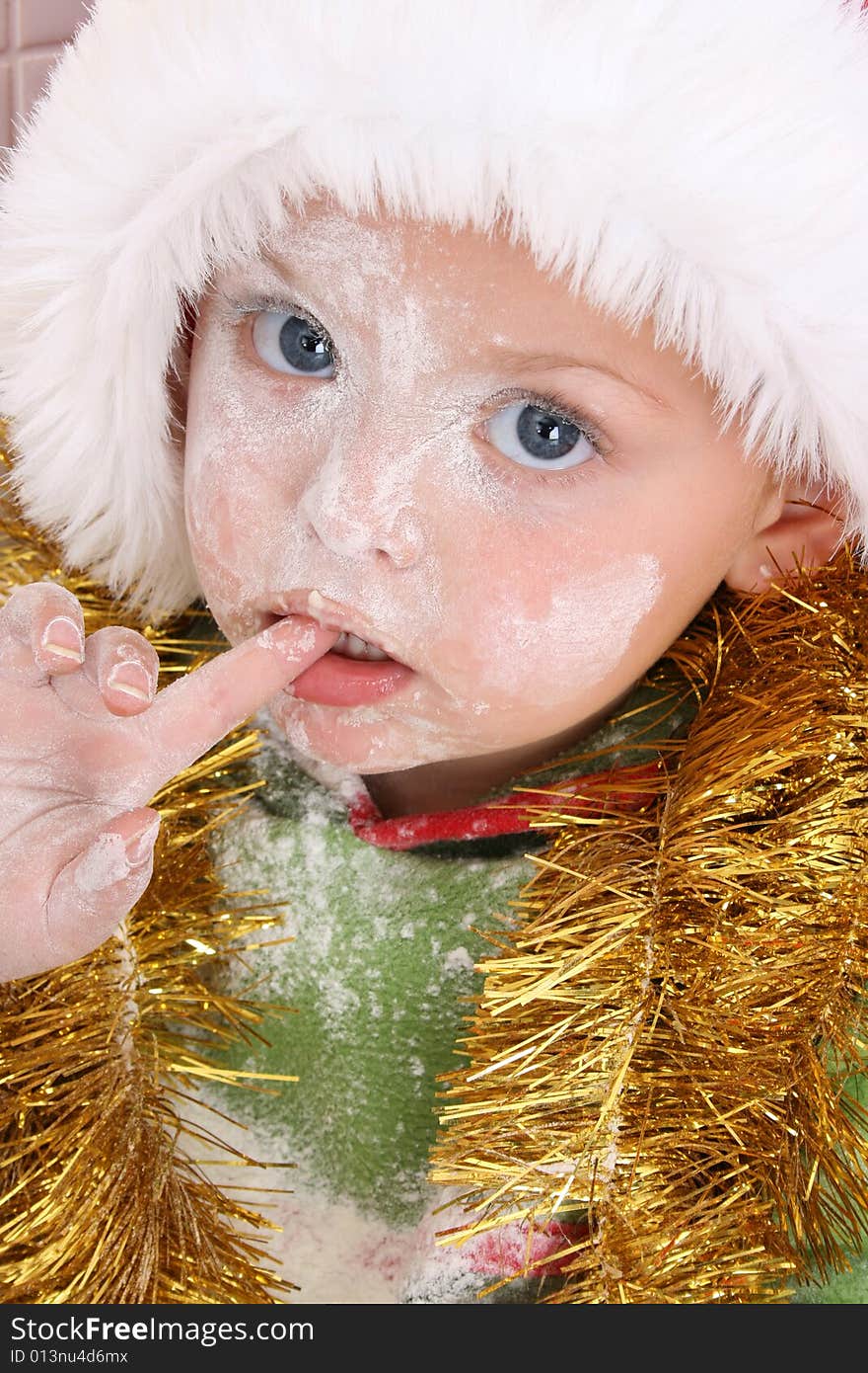 Toddler wearing a christmas hat, baking christmas cookies