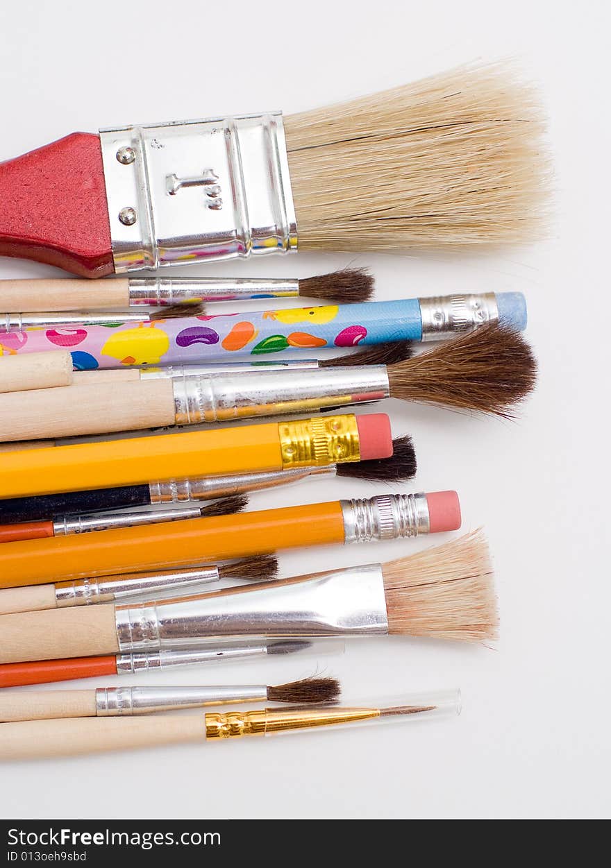 Pencils and brushes closeup at white background