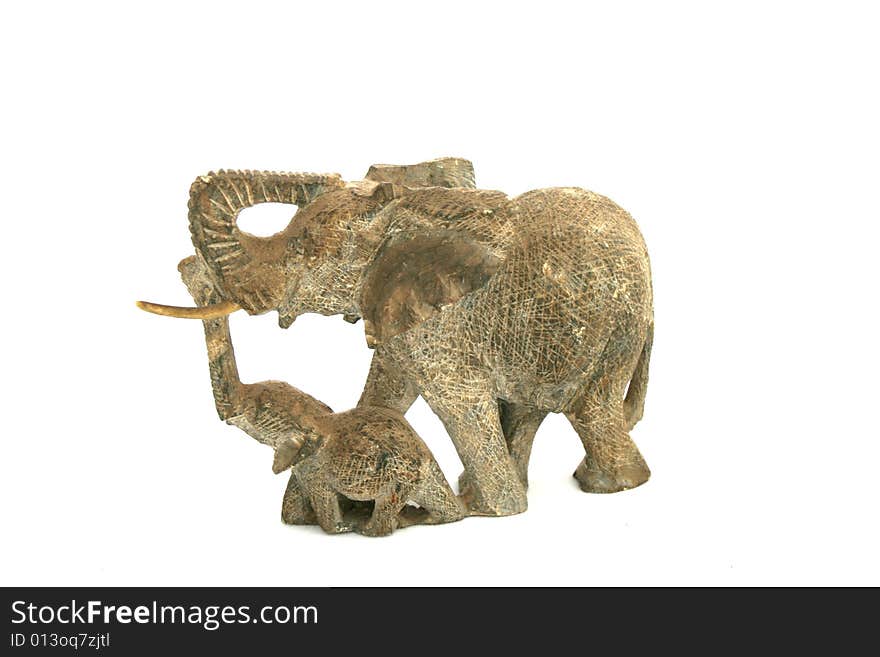 A hand carved mother elephant and her calf isolated on a white background. A hand carved mother elephant and her calf isolated on a white background