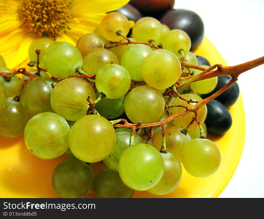 Green grapes and plumps on plate