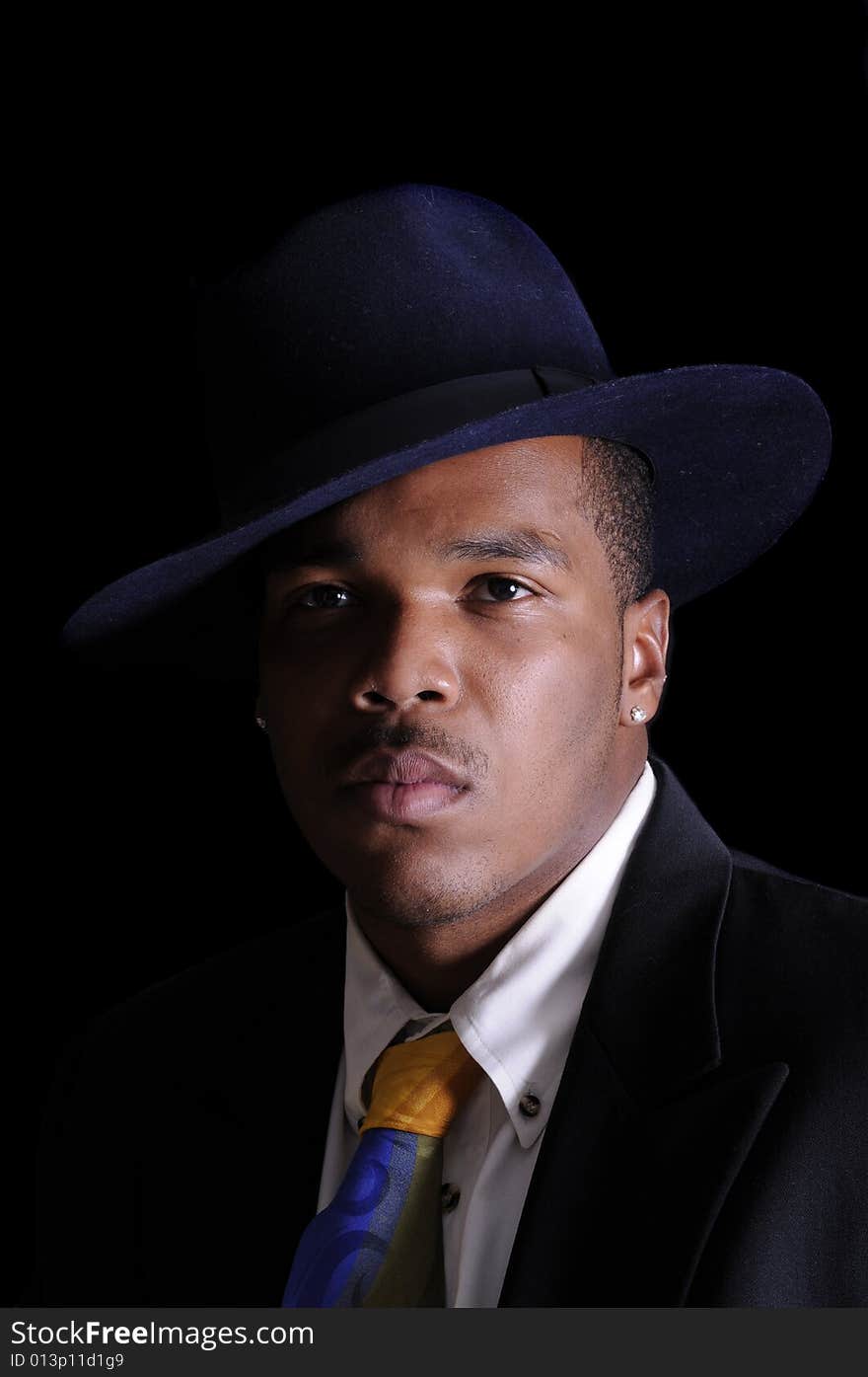 Young African American man in a hat and suit