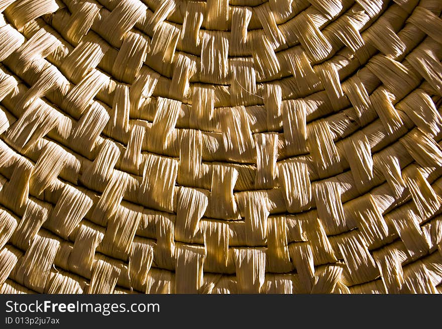 Detail of a container made of straw, with hard contrast, enlightened from right by flash light source. Detail of a container made of straw, with hard contrast, enlightened from right by flash light source