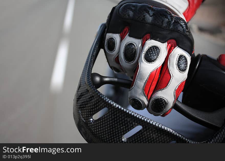 A biker's hand in a leather glove, on a motorcycle at high speed. A biker's hand in a leather glove, on a motorcycle at high speed