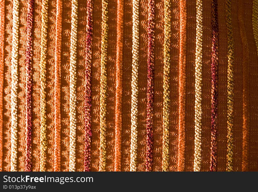 Detail of a vertical row tissue pillow, on red, orange, and purple tones. Detail of a vertical row tissue pillow, on red, orange, and purple tones