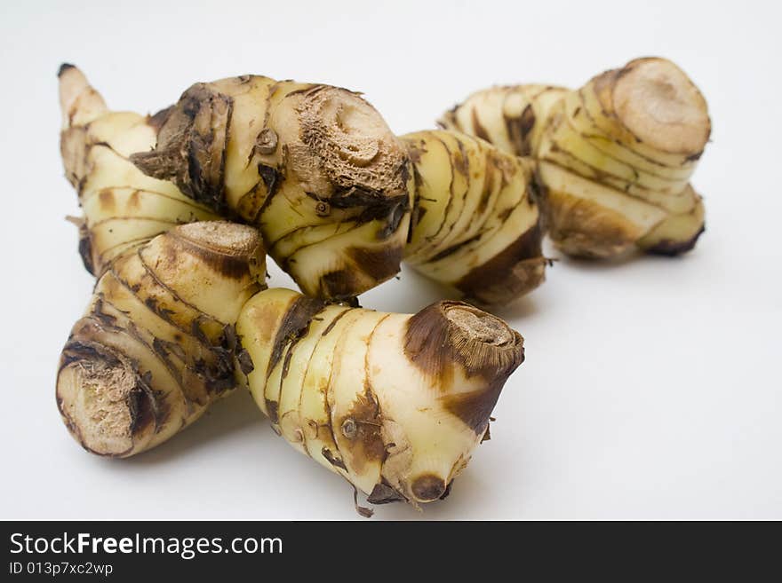 A stack of galangal root isolated against a white background