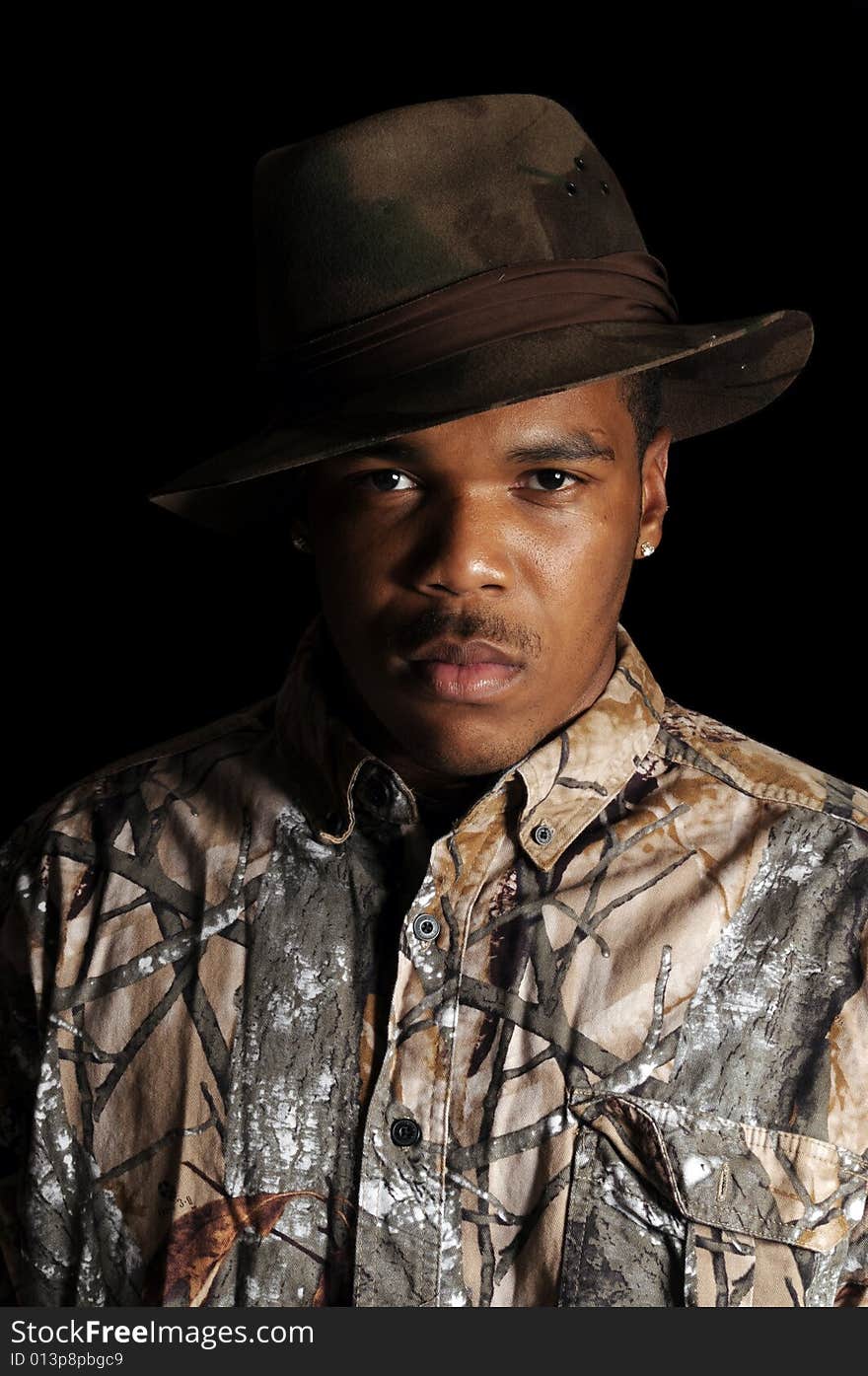 Young African American man in a hat and camouflage shirt