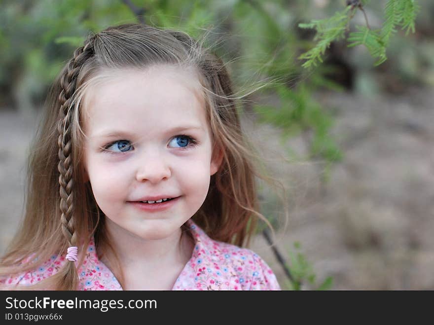 Young girl looking up and to the side with her hair blowing in the wind