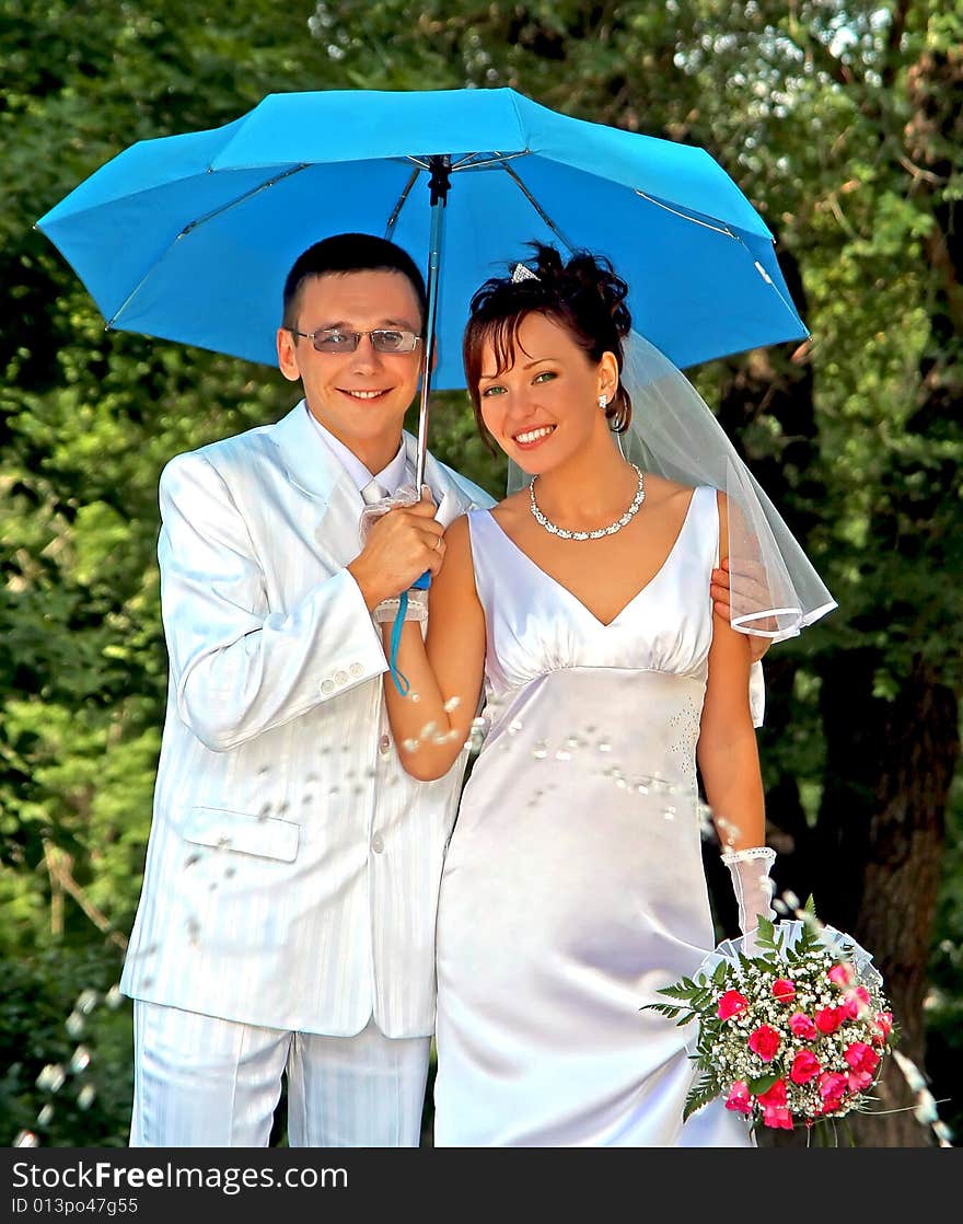 Bridegroom and bride with the umbrella