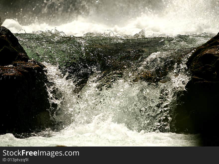 The bottom of a waterfall with flowing water. The bottom of a waterfall with flowing water