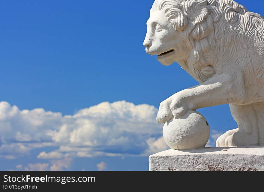 Sculpture of a white lion on a background of the blue sky