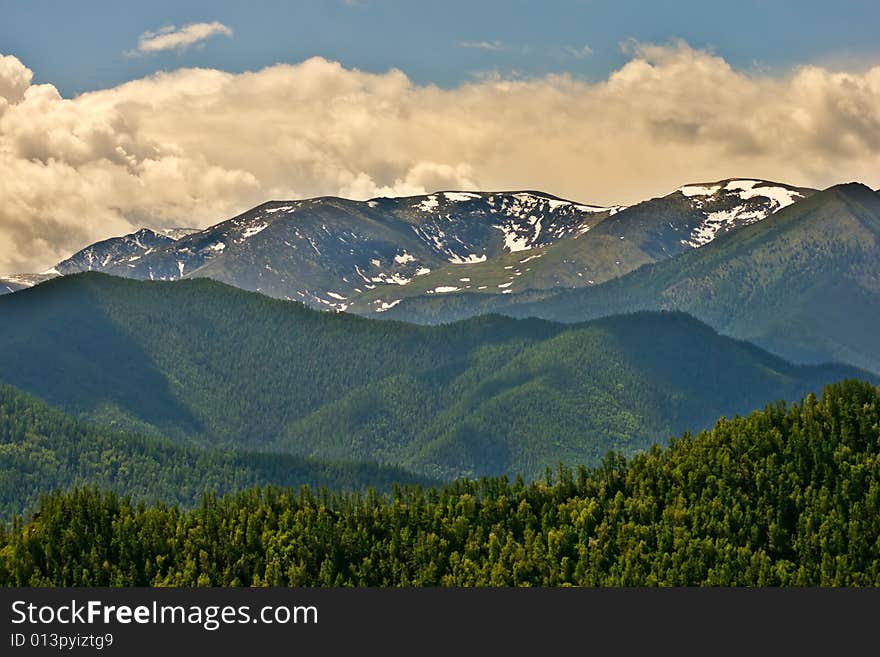 Remote glacier and clouds in mountains