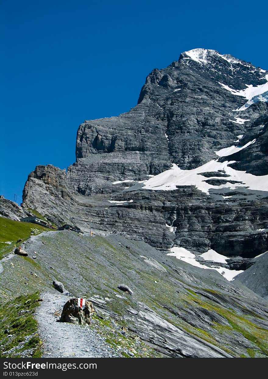 Panorama with Eiger (3970 m) mountain in Switzerland Alps. The Eiger is a mountain in the Swiss Alps (Bernese Oberland) with a high of 3970 m. The first ascent of the Eiger was made by Swiss guides Christian Almer and Peter Bohren and Irishman Charles Barrington who climbed the west flank on August 11, 1858. Panorama with Eiger (3970 m) mountain in Switzerland Alps. The Eiger is a mountain in the Swiss Alps (Bernese Oberland) with a high of 3970 m. The first ascent of the Eiger was made by Swiss guides Christian Almer and Peter Bohren and Irishman Charles Barrington who climbed the west flank on August 11, 1858.