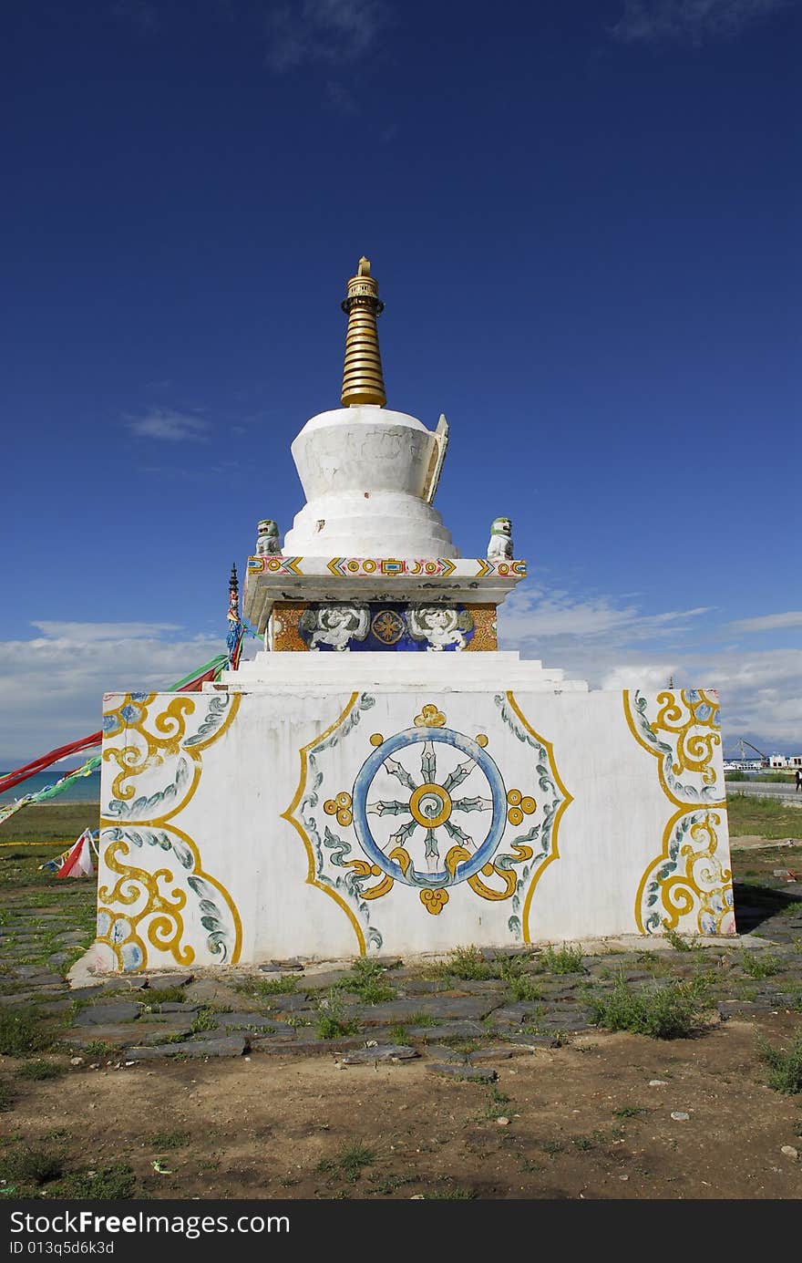 White Pagoda on Base with Tibetan Decoration against Blue Sky