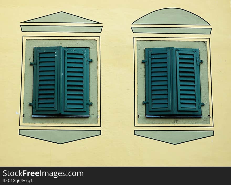 Two Turquoise Windows With Closed Shutters