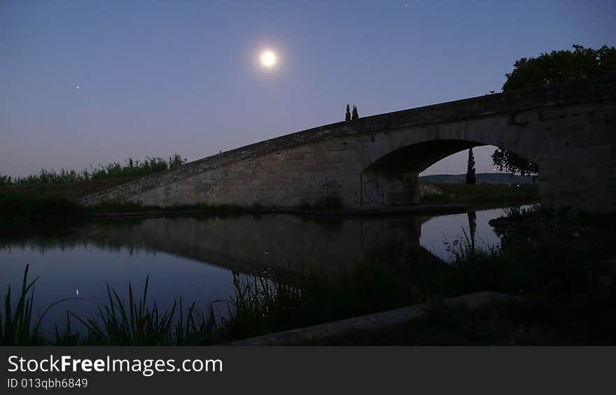 A bridge standing on the canal-du-midi in the moolight. A bridge standing on the canal-du-midi in the moolight