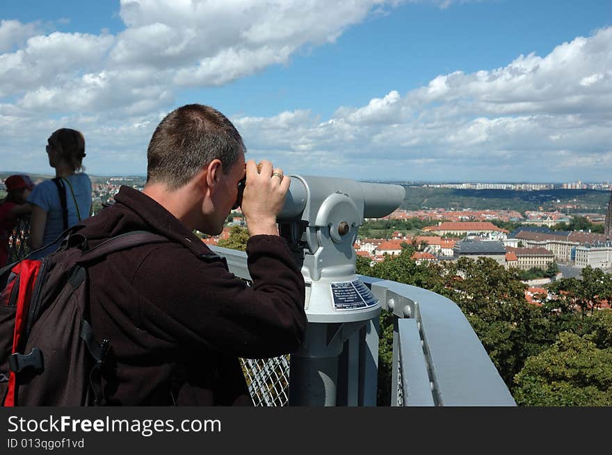 Man on the balcony is looking through binocular. Man on the balcony is looking through binocular