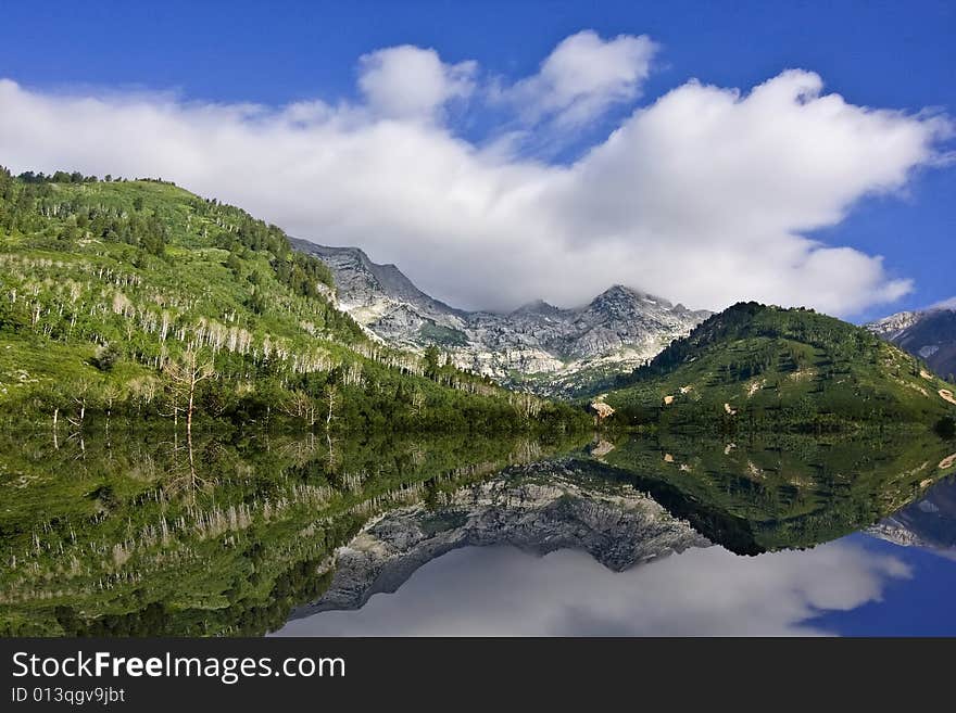 Mountain Lake showing 
 reflectionswith blue sky and clouds. Mountain Lake showing 
 reflectionswith blue sky and clouds