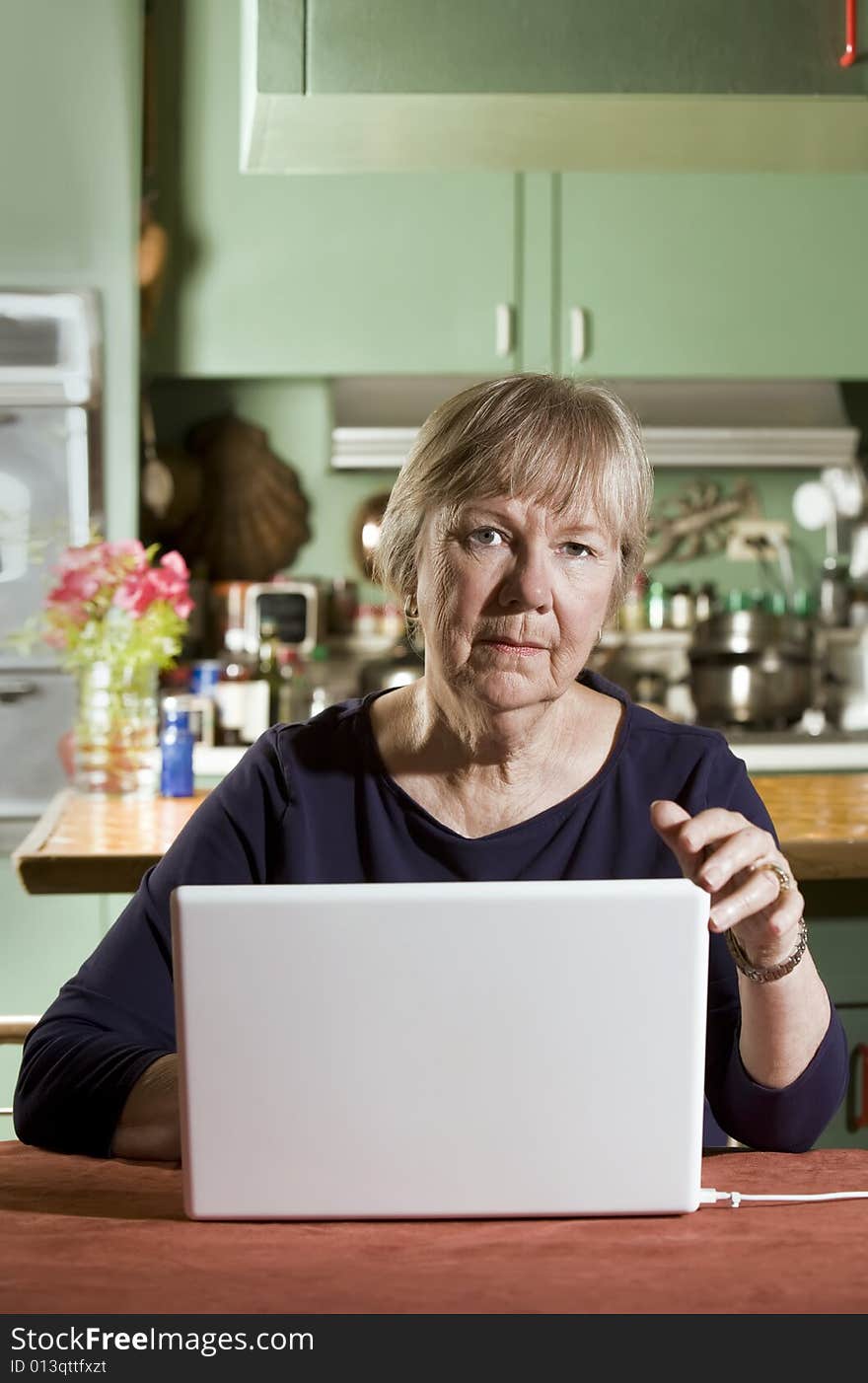 Senior in Dining Room with a Laptop Computer. Senior in Dining Room with a Laptop Computer