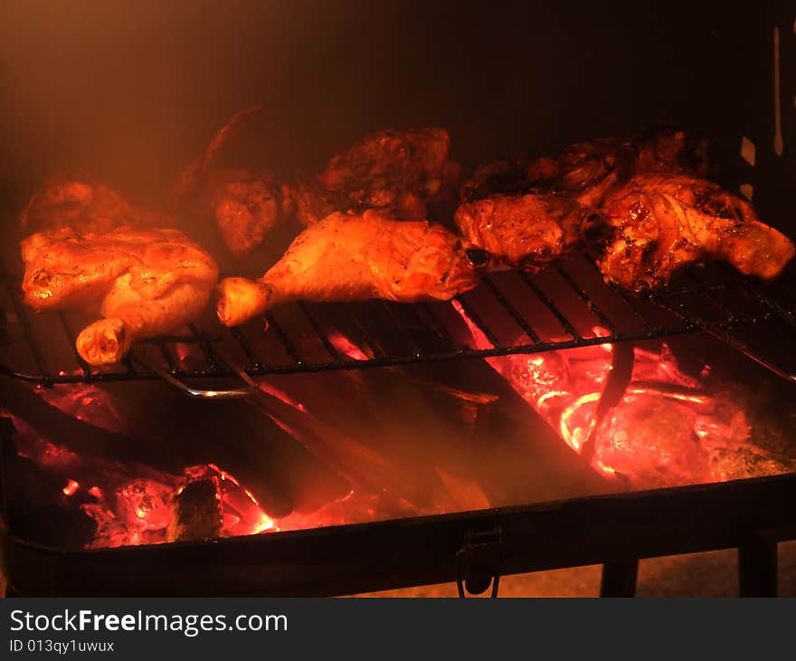 Chicken on a grill with smoke on left side